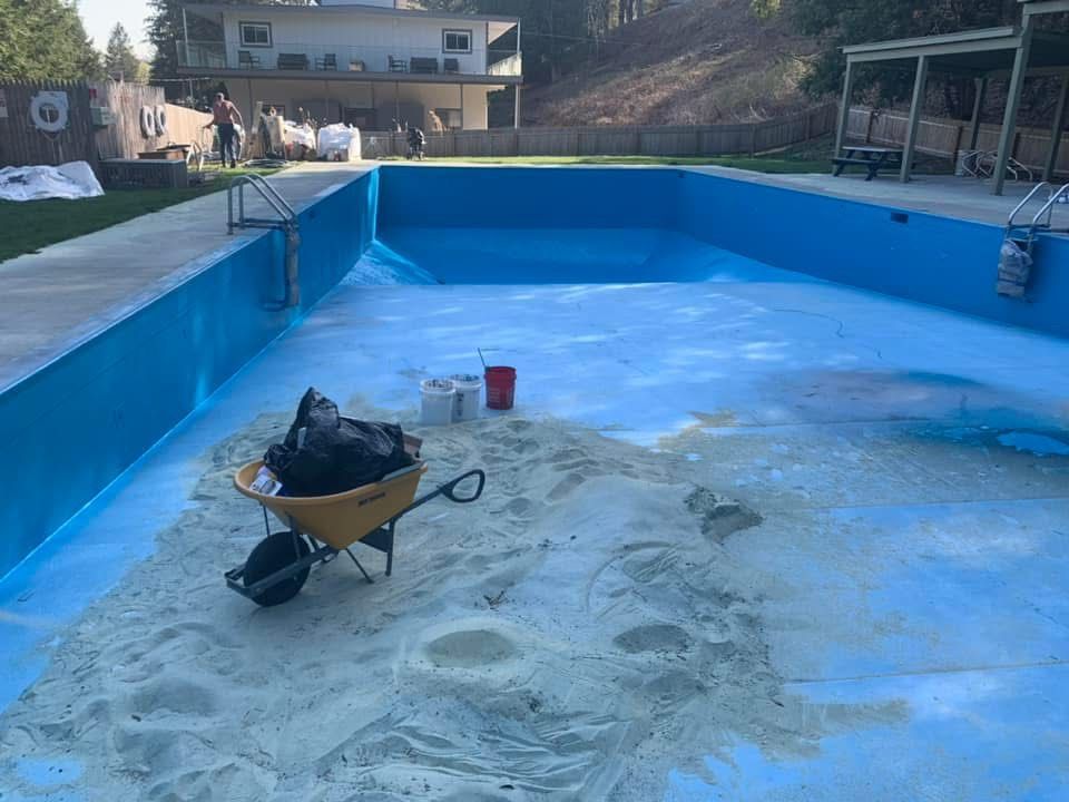 A wheelbarrow is sitting in the middle of a swimming pool.