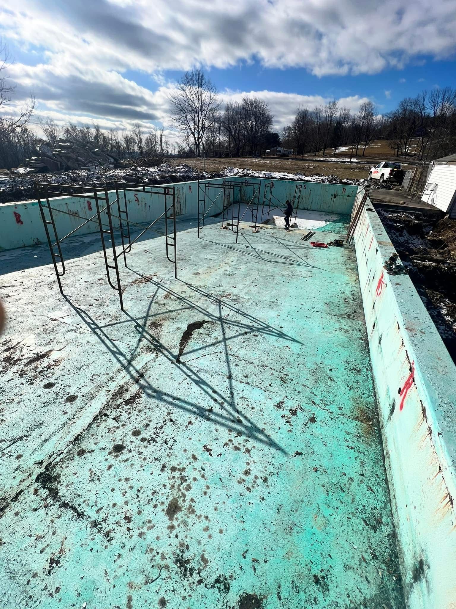 A large swimming pool is being built in the snow.