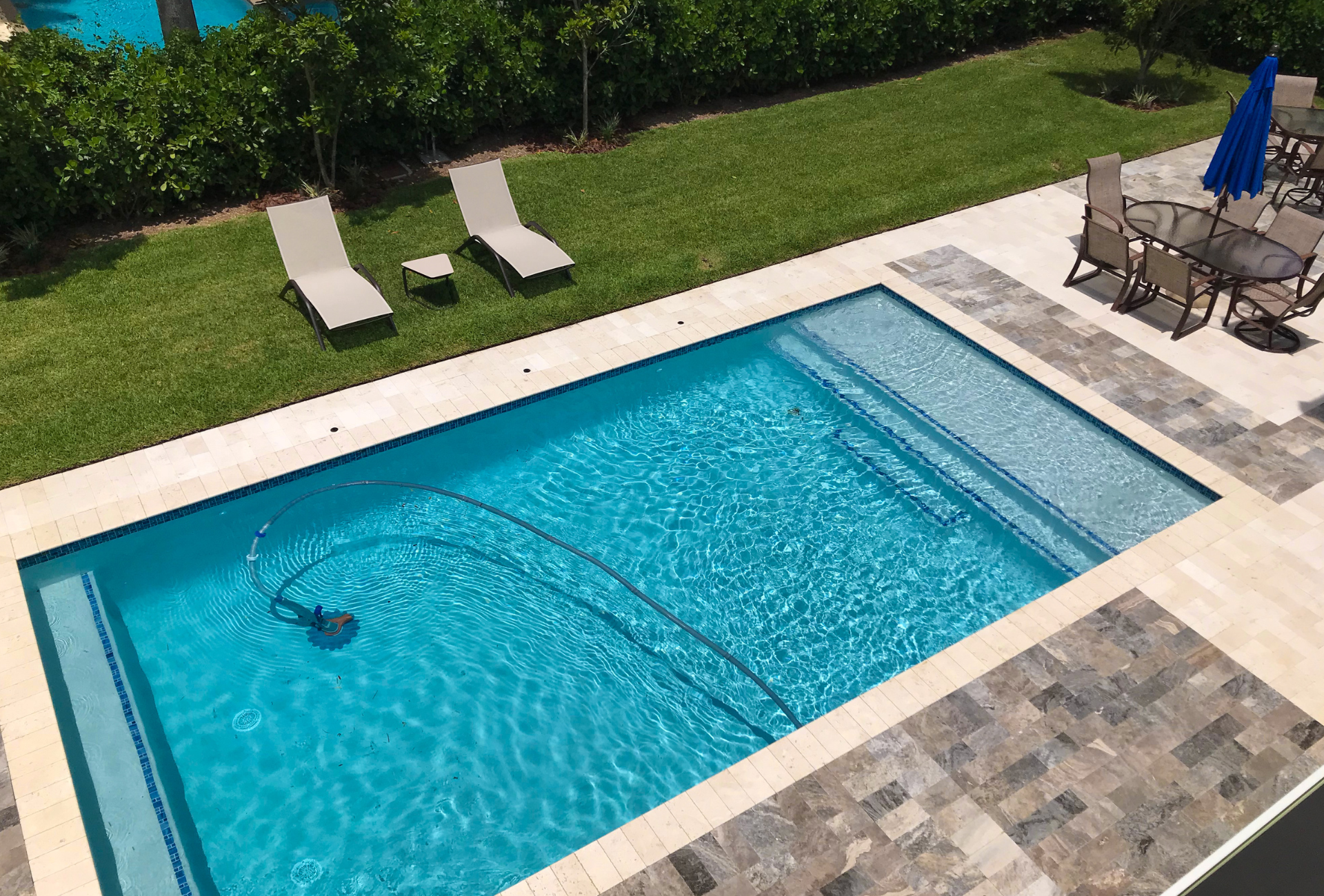 A cleaning kit is sitting next to a swimming pool.