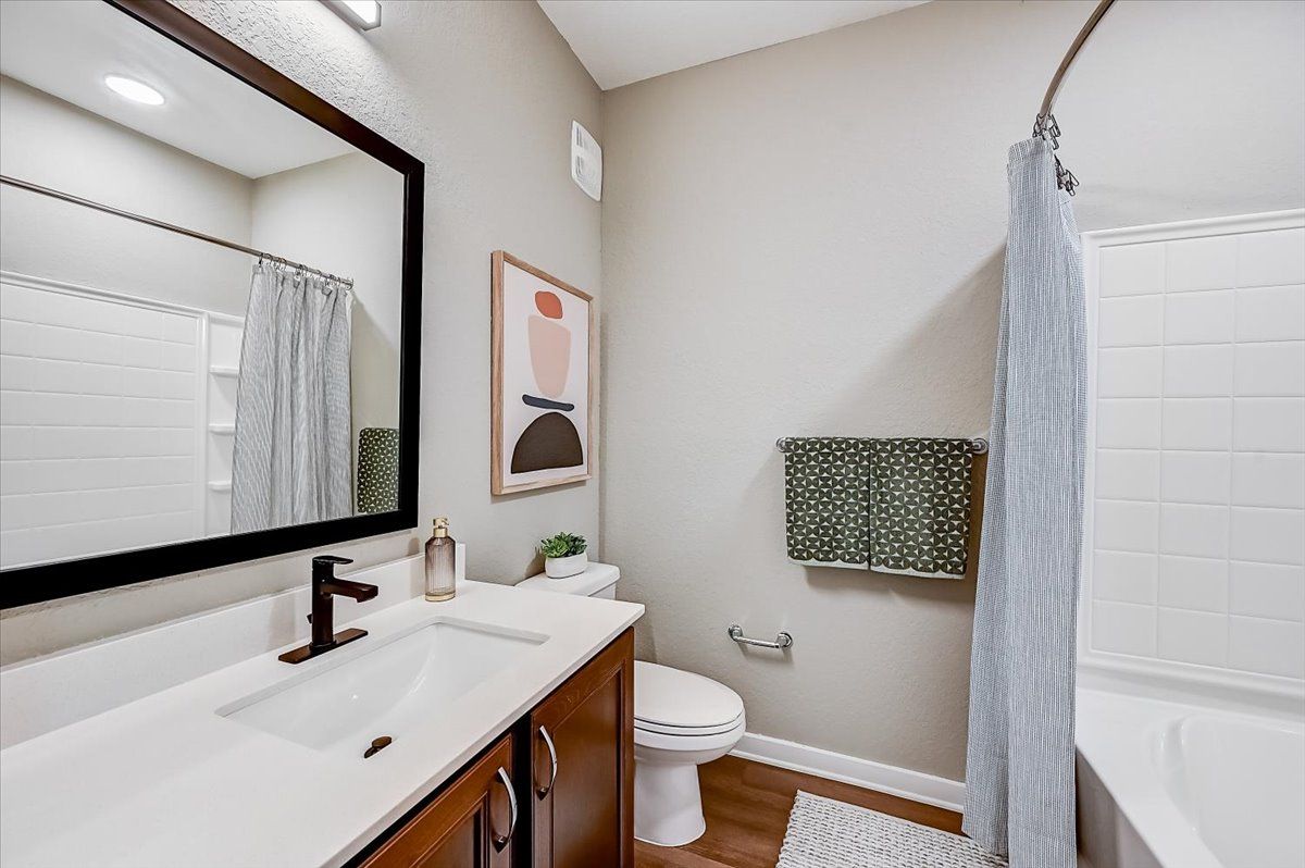updated bathroom with a large vanity and mirror, plus a shower/tub combo
