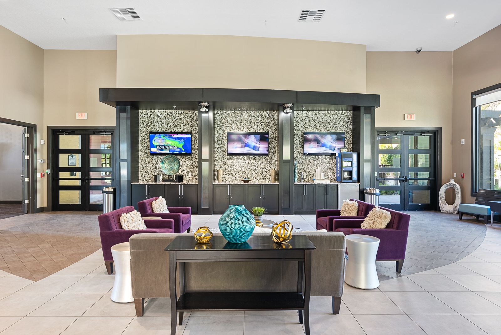 entertainment lounge area with three mounted tvs and comfortable srating