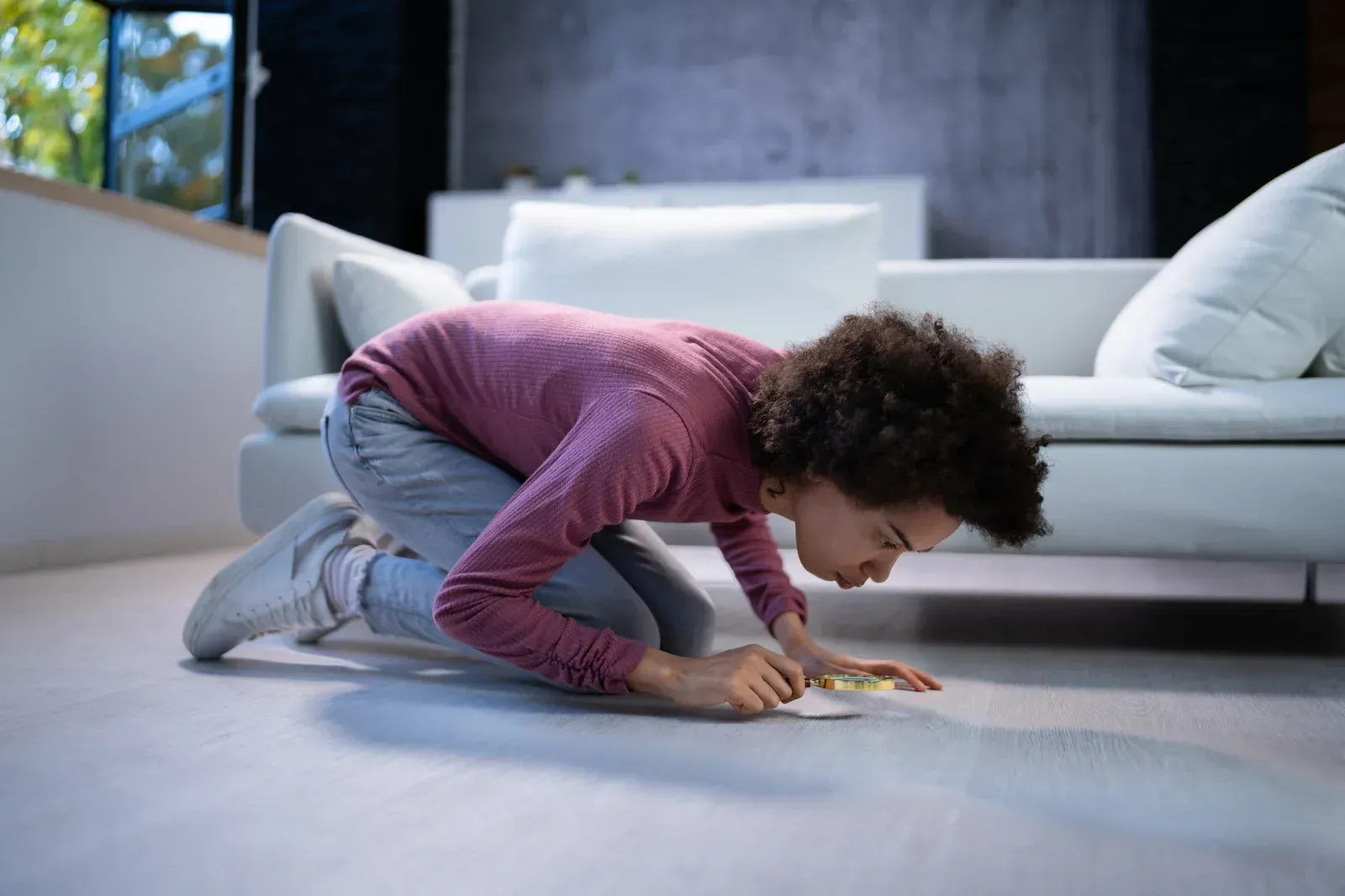 A young boy is crawling on the floor in a living room.