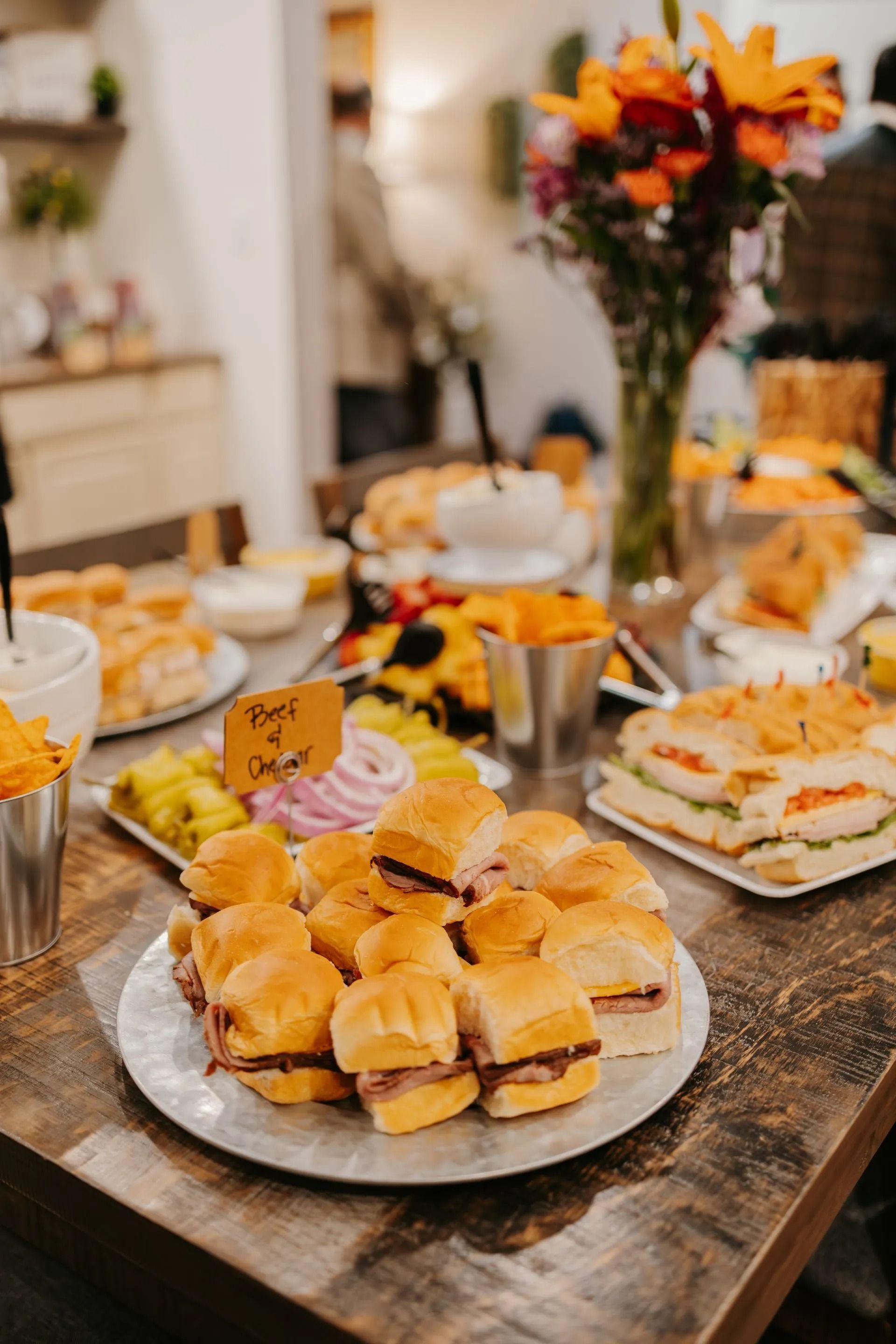 A table topped with plates of food and a vase of flowers.