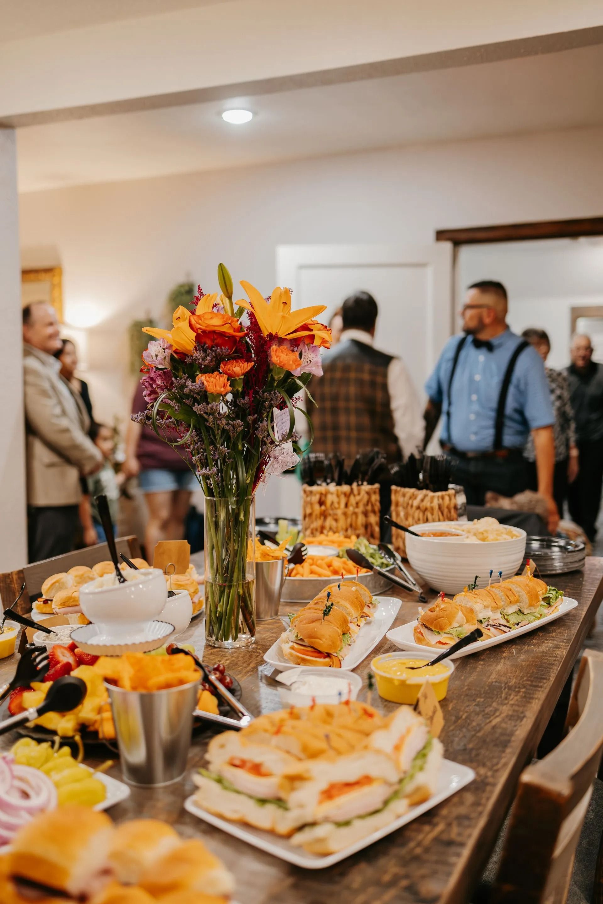 A table topped with plates of food and a vase of flowers.