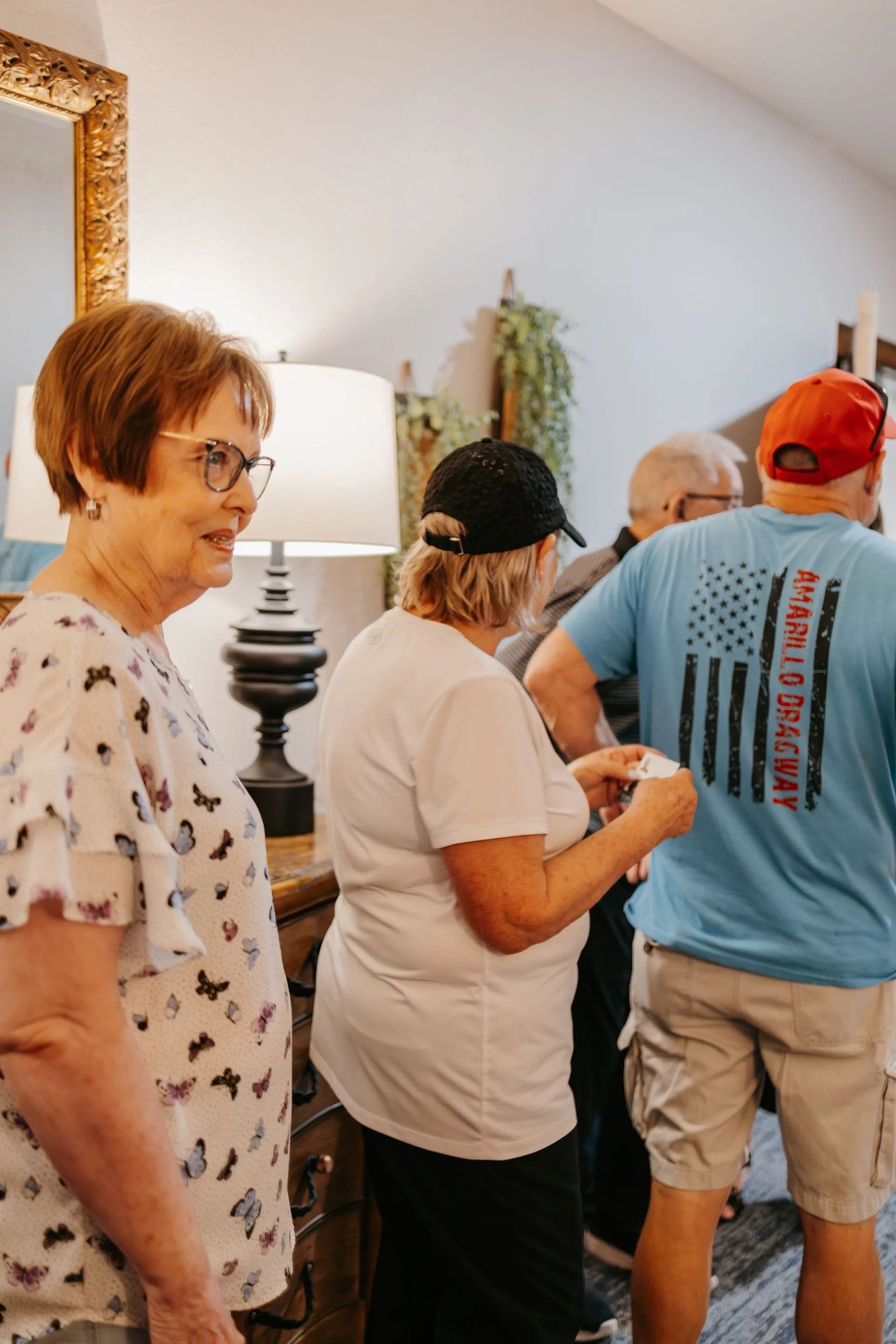 A group of people are standing in a living room.