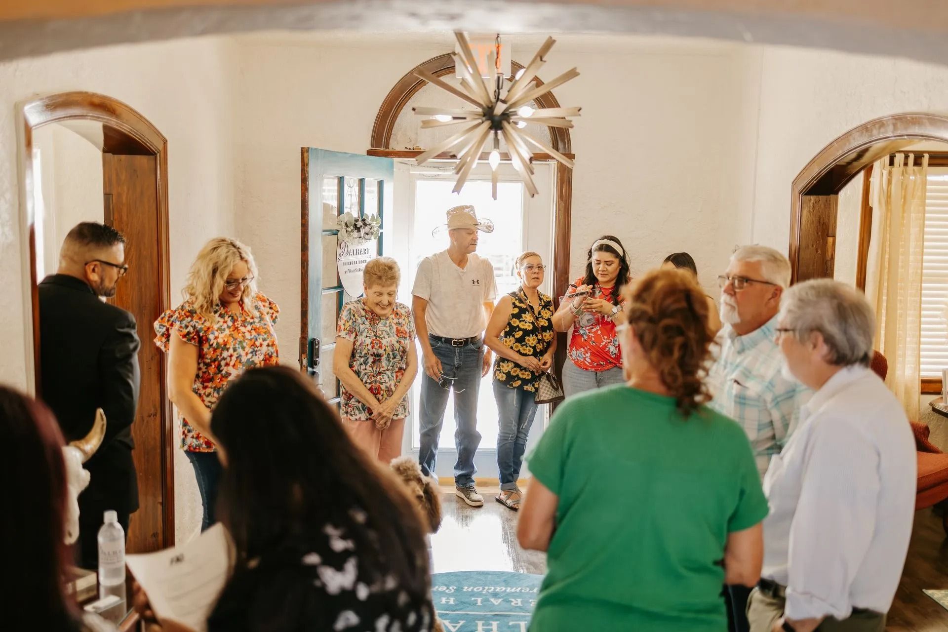 A group of people are standing in a room in front of a door.
