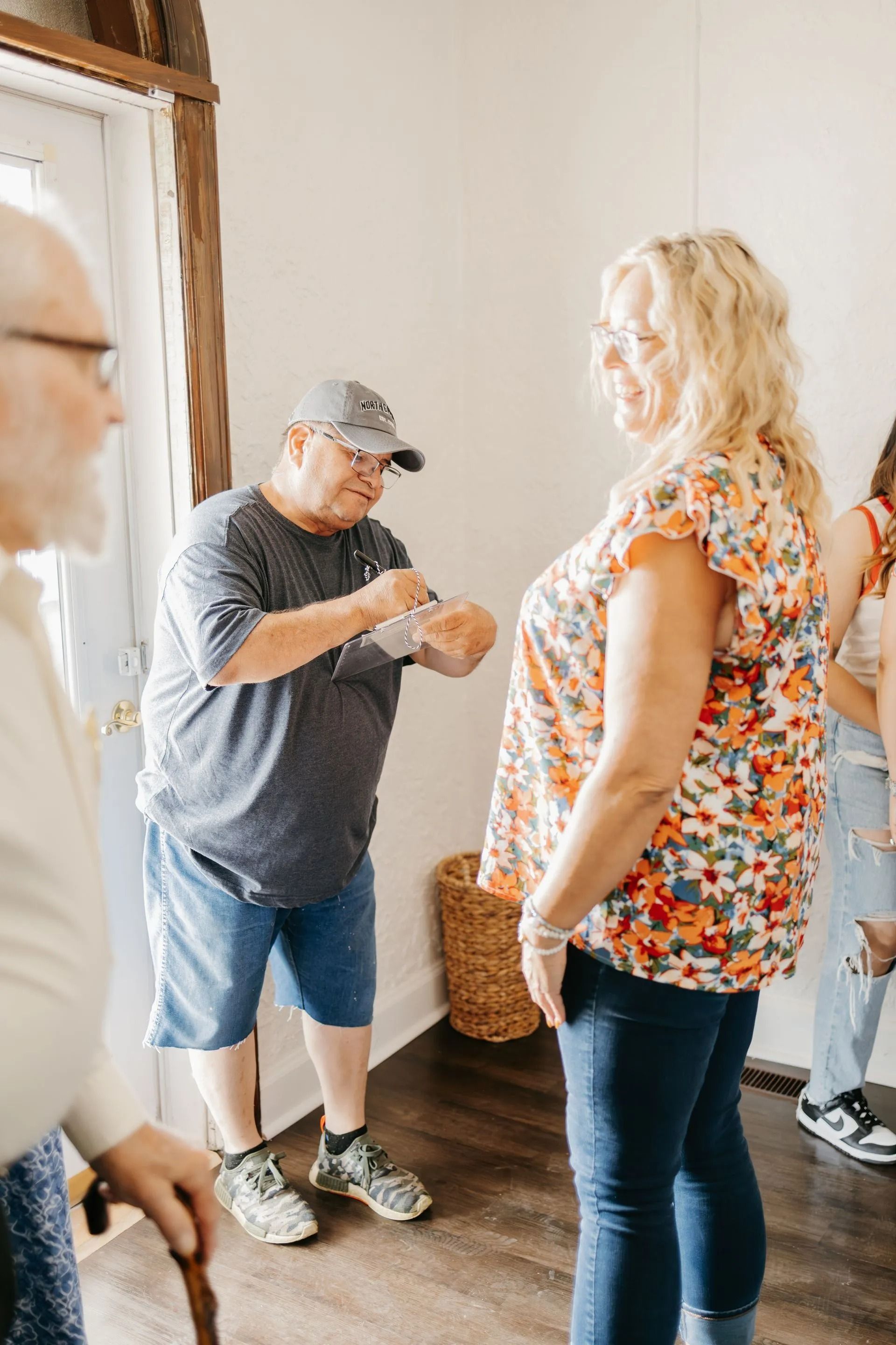A group of people are standing in a room talking to each other.