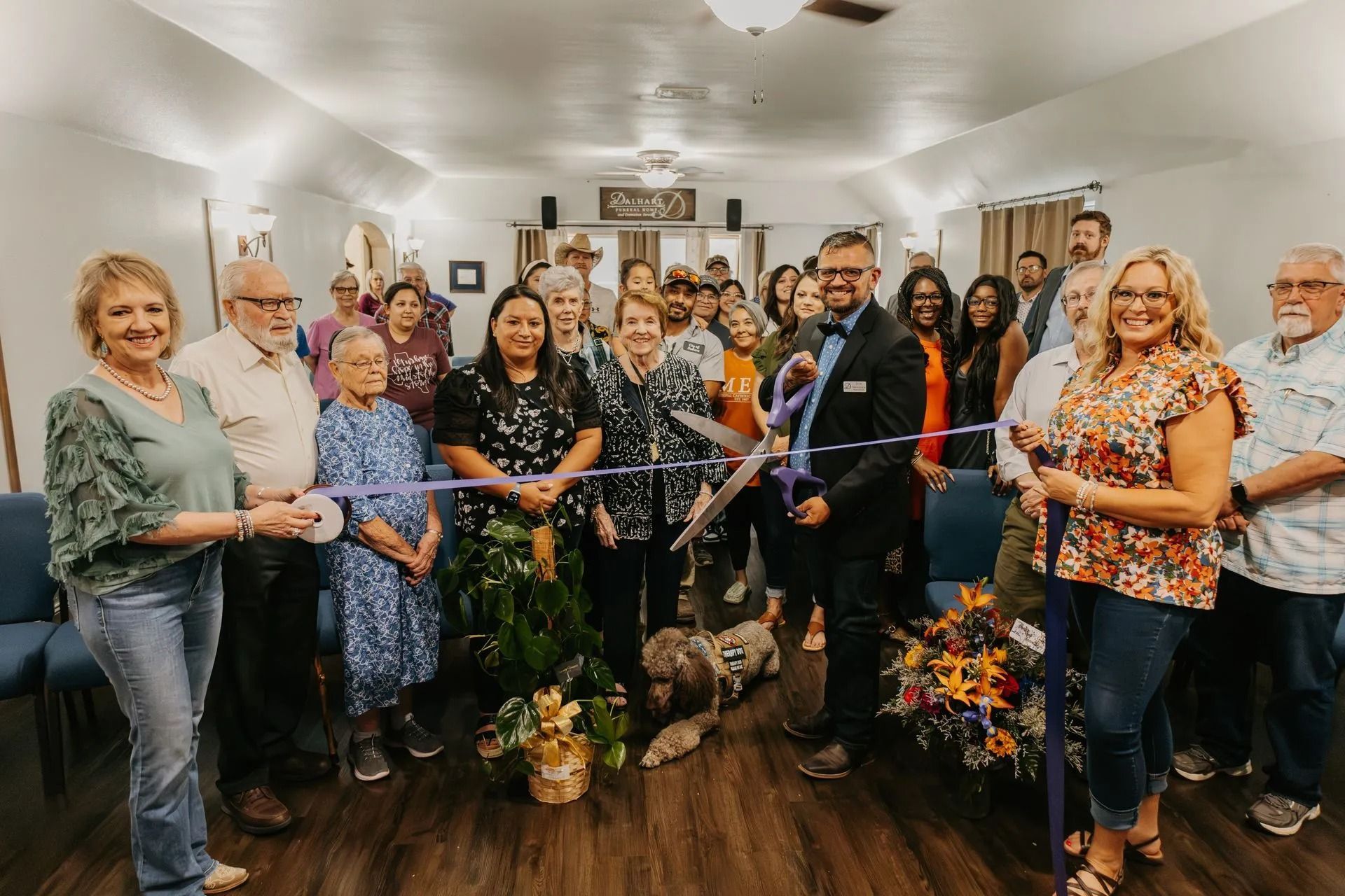 A group of people are cutting a ribbon in a room.