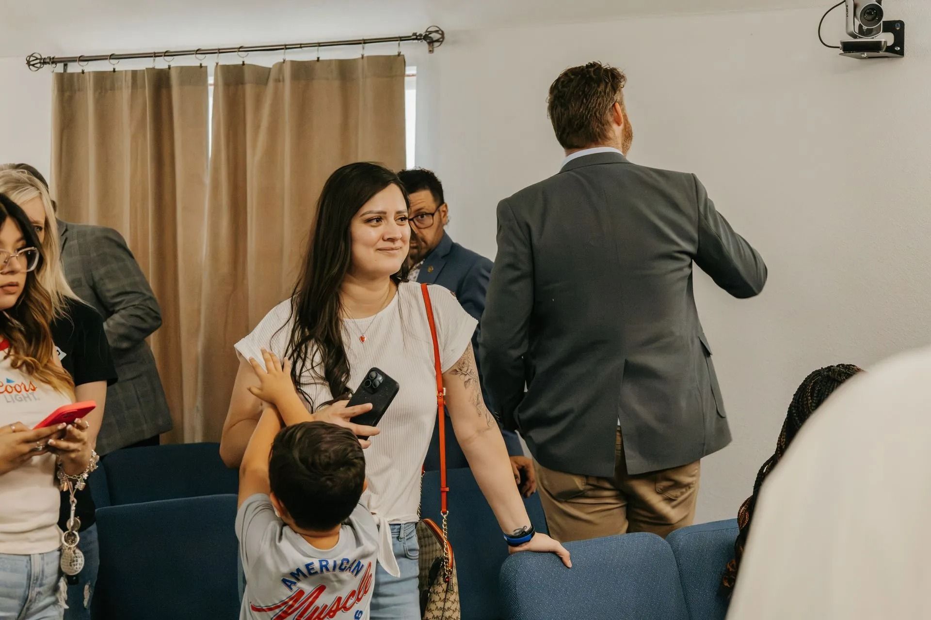 A woman is holding a child in her arms in a living room.