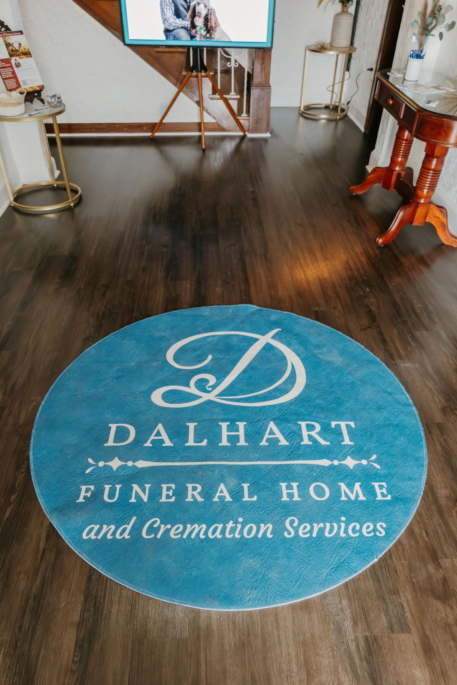 A blue rug with the dalhart funeral home and cremation services logo on it.