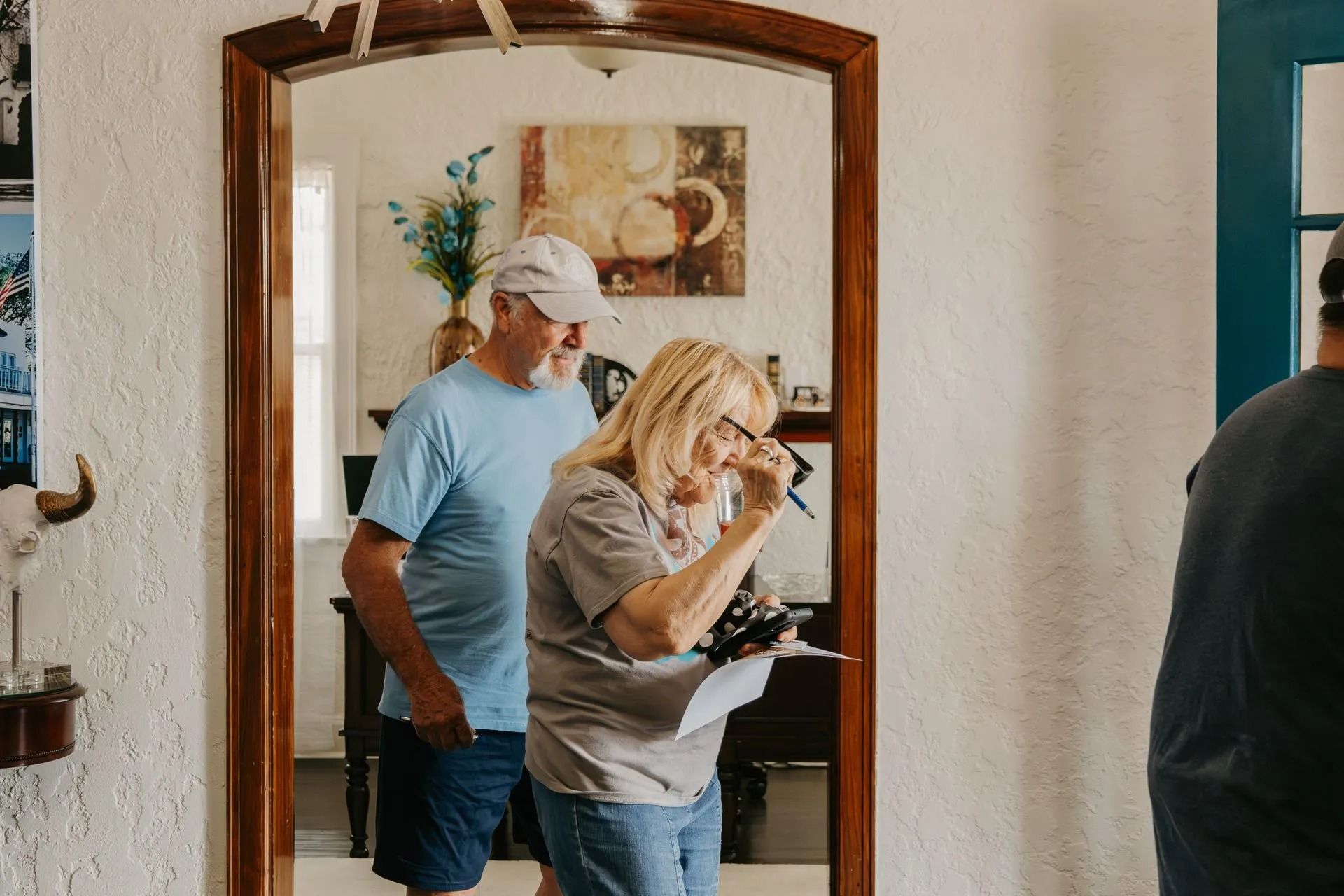 A man and a woman are standing in front of a mirror.
