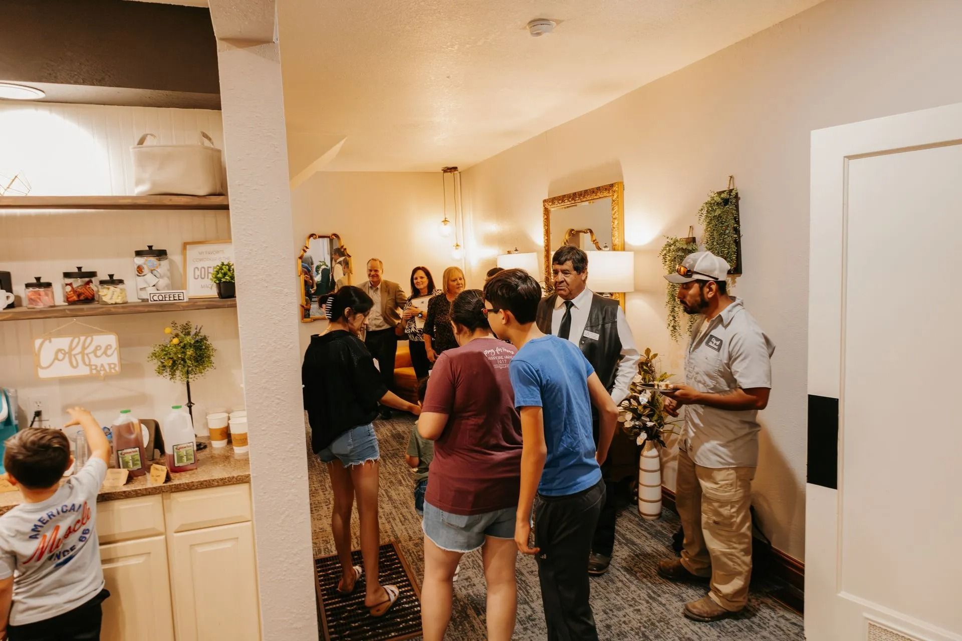 A group of people are standing in a living room talking to each other.