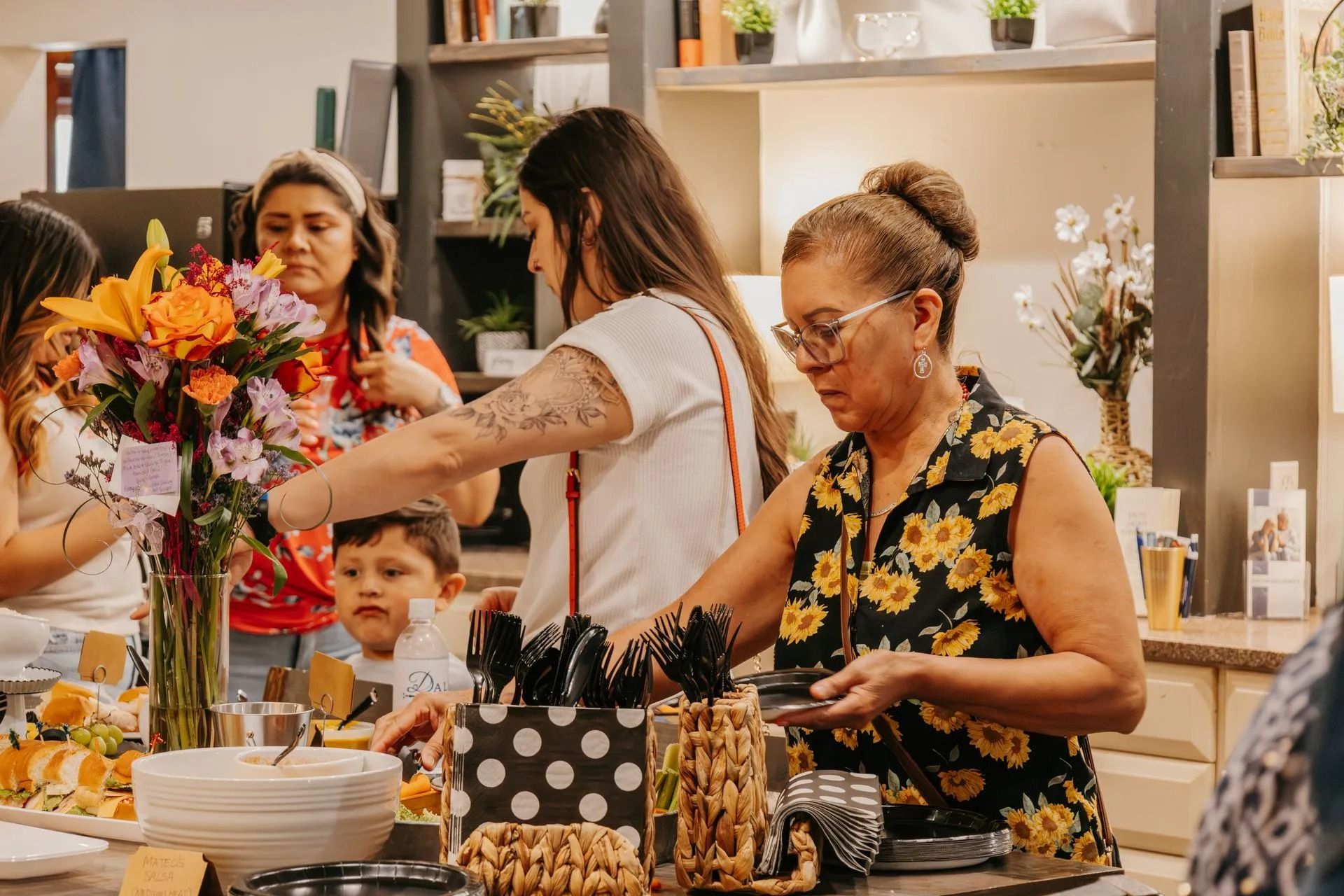 A group of women are standing around a table serving food.