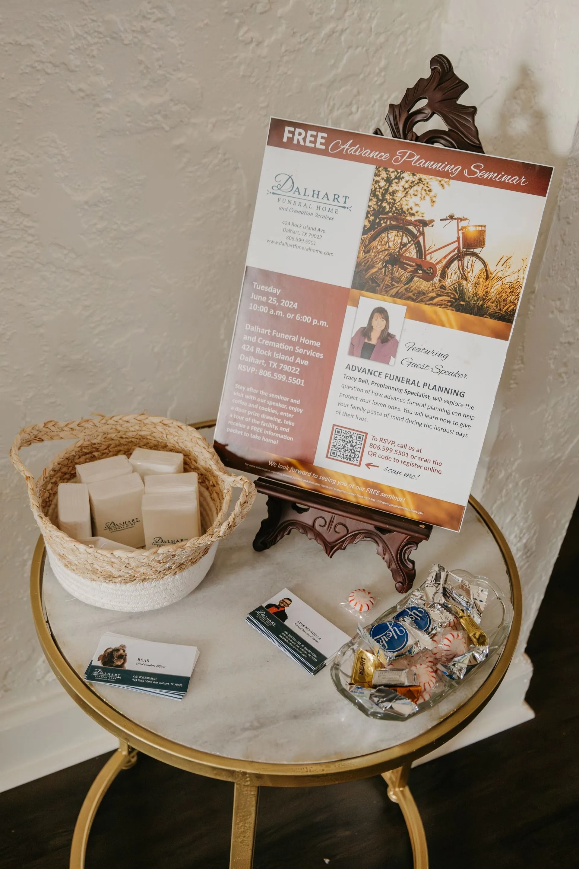 A table with a sign on it and a basket of soap on it.