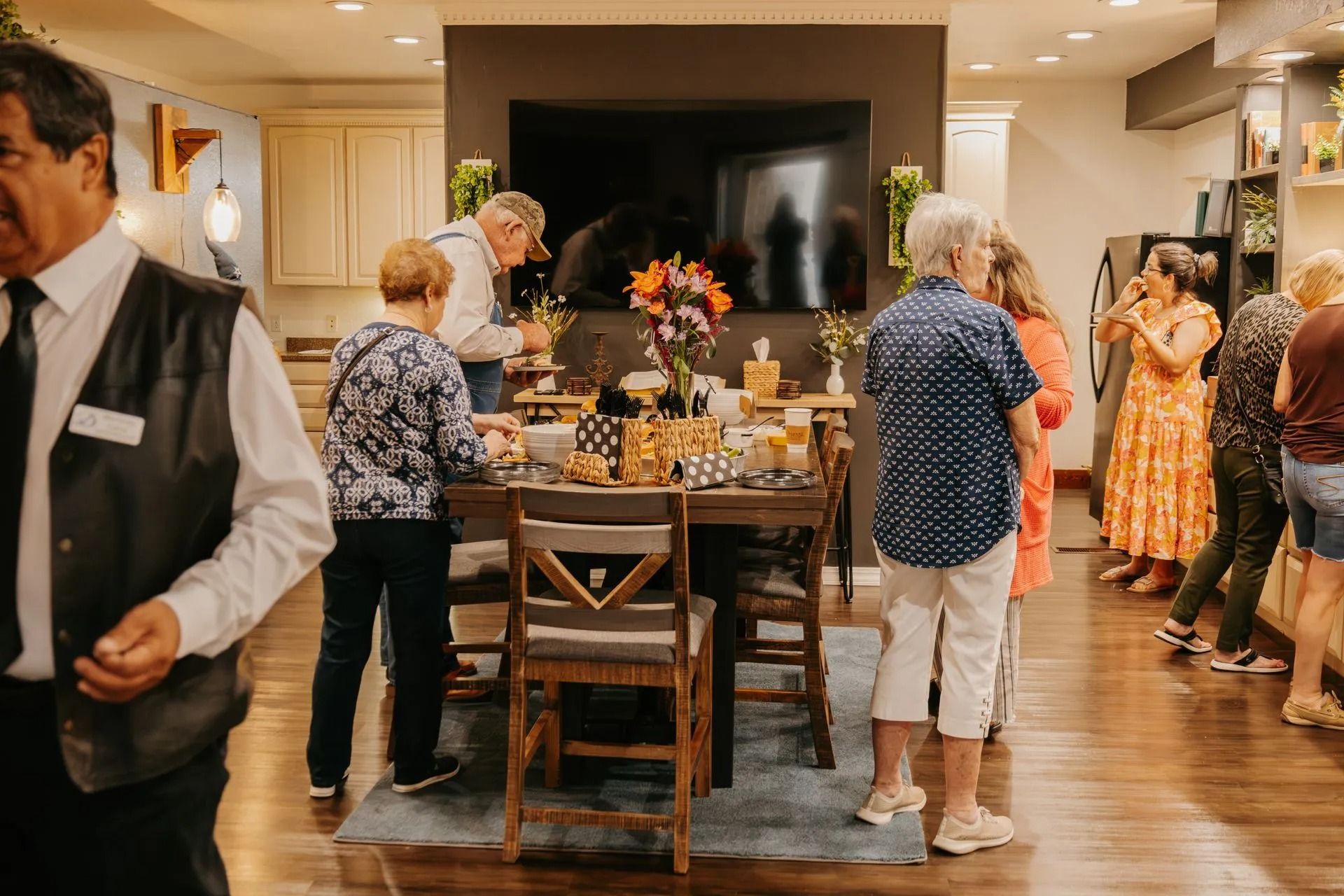 A group of people are standing around a table in a room.
