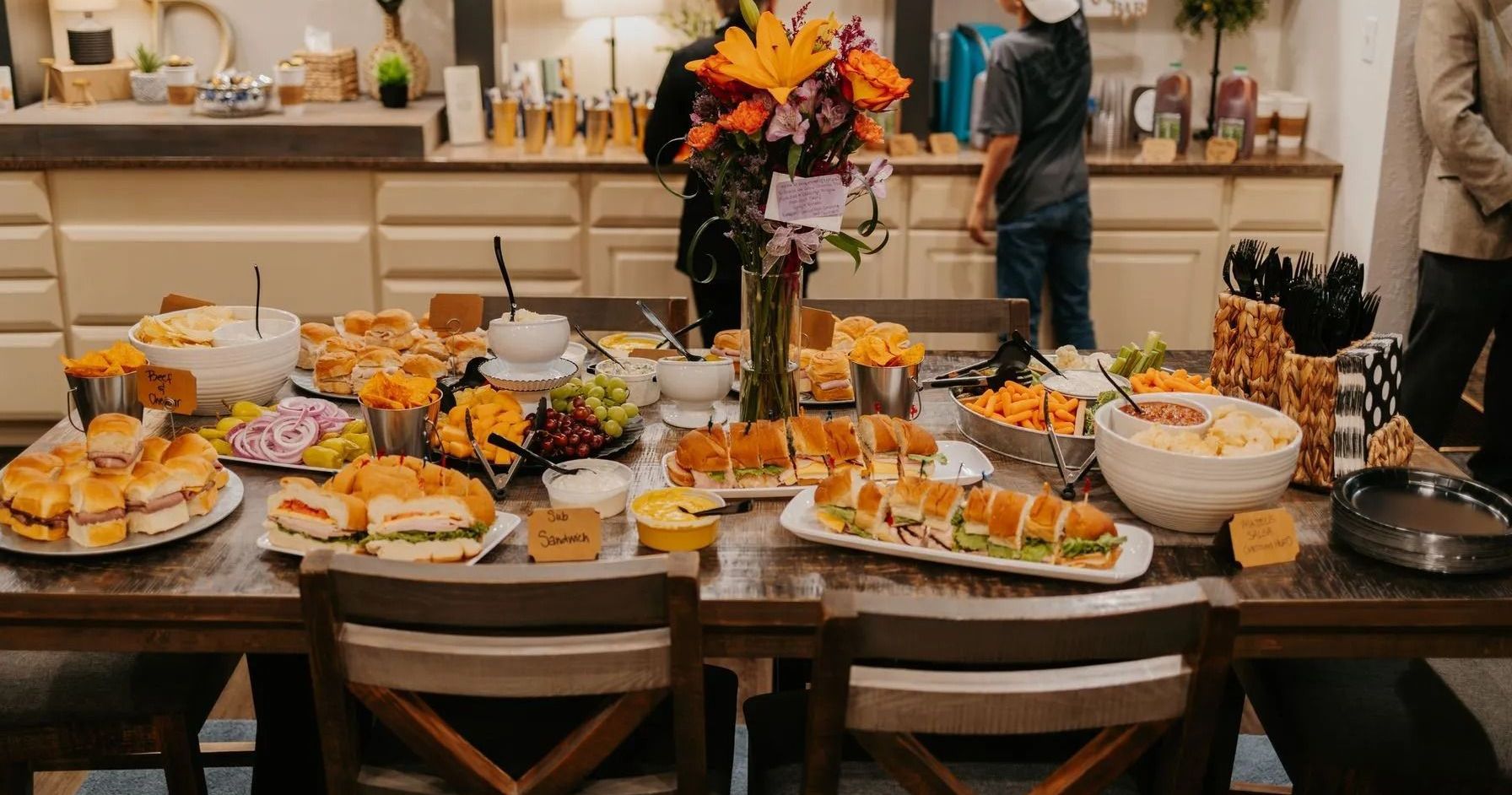 A table topped with plates of food and a vase of flowers.
