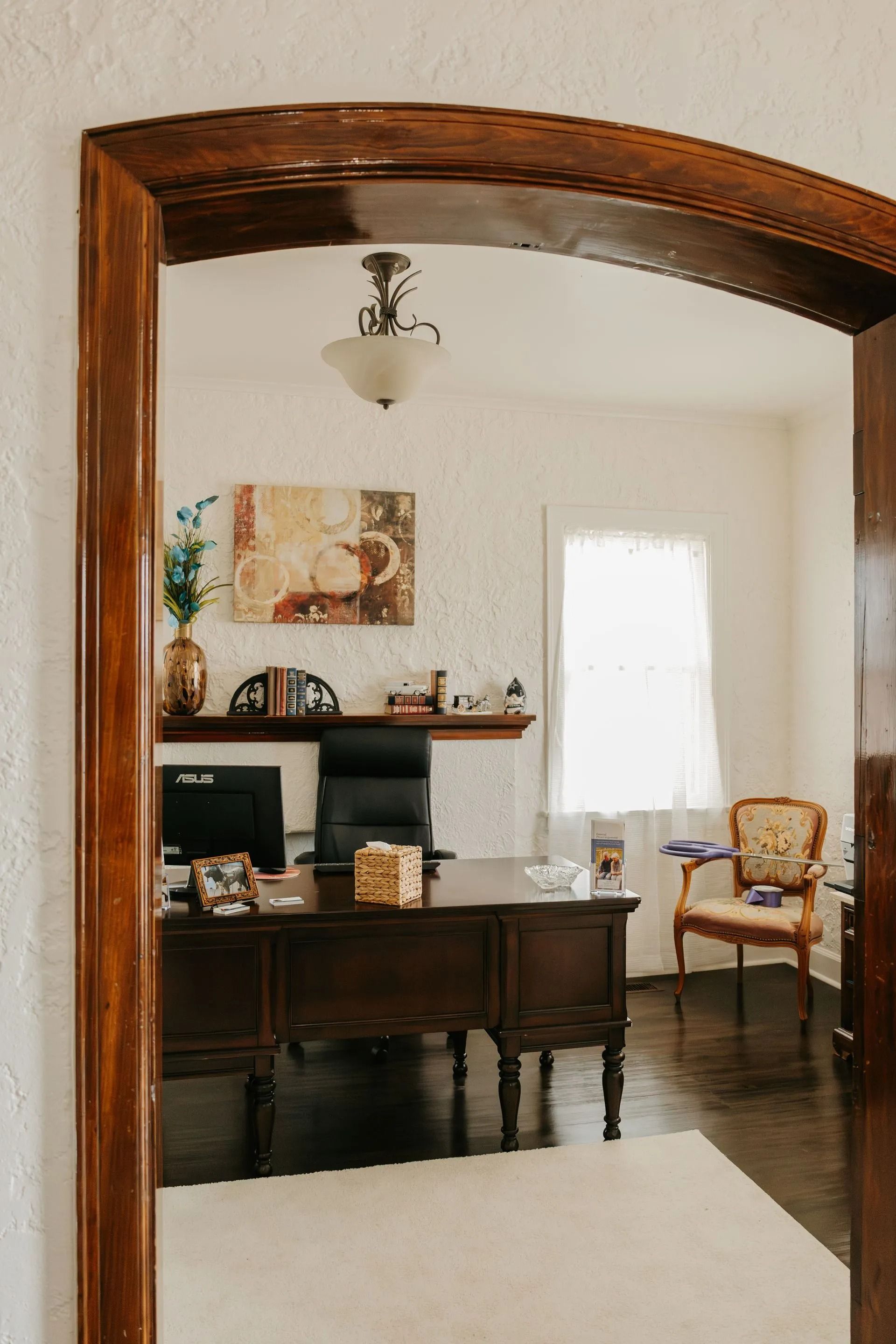A view of a home office through a wooden archway.