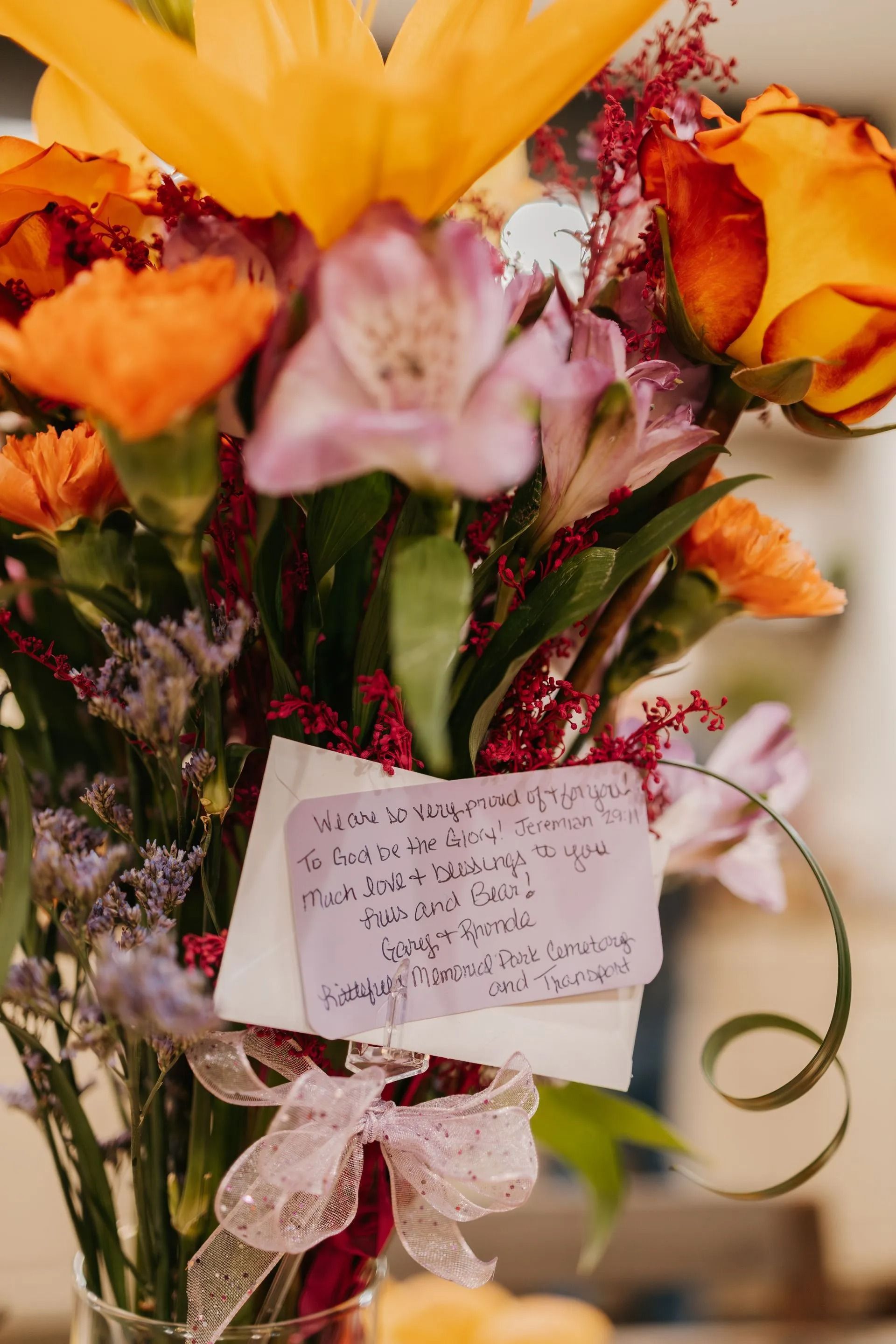 A bouquet of flowers with a note attached to it
