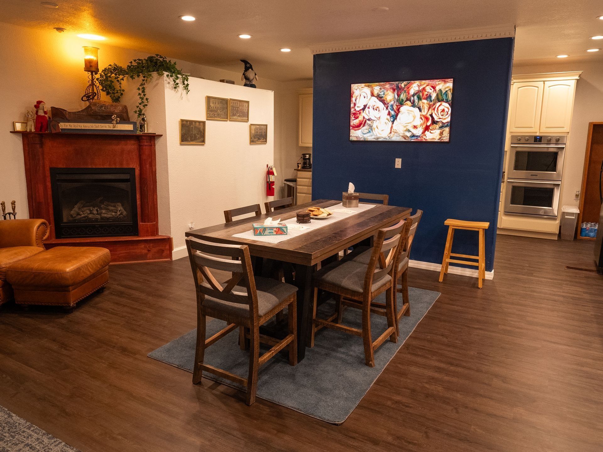 A living room with a dining table and chairs and a fireplace.