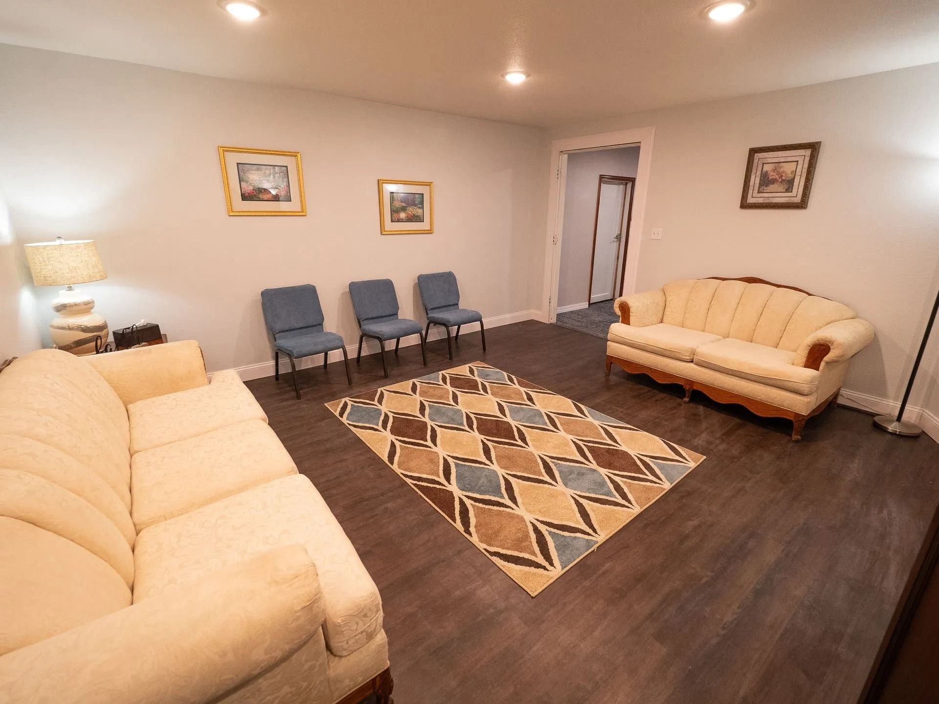 A living room with a couch , chairs and a rug.