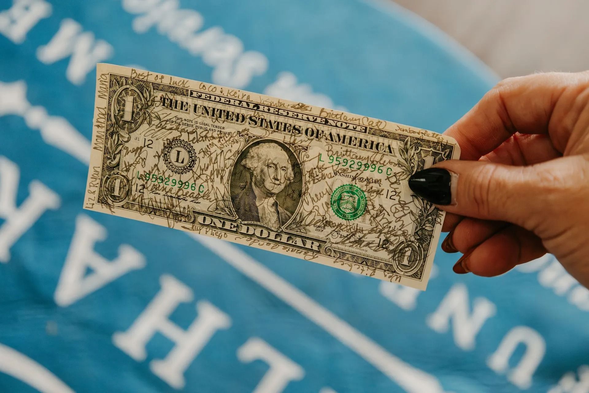 A person is holding a dollar bill in their hand.