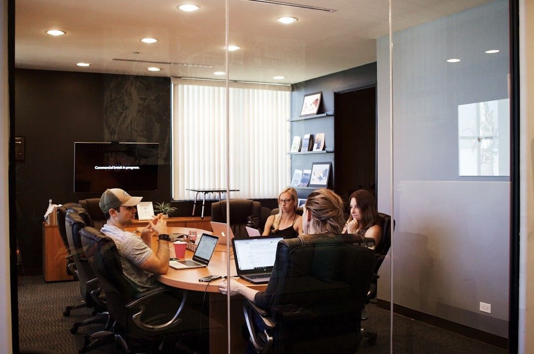 A group of people are sitting around a table in a conference room.