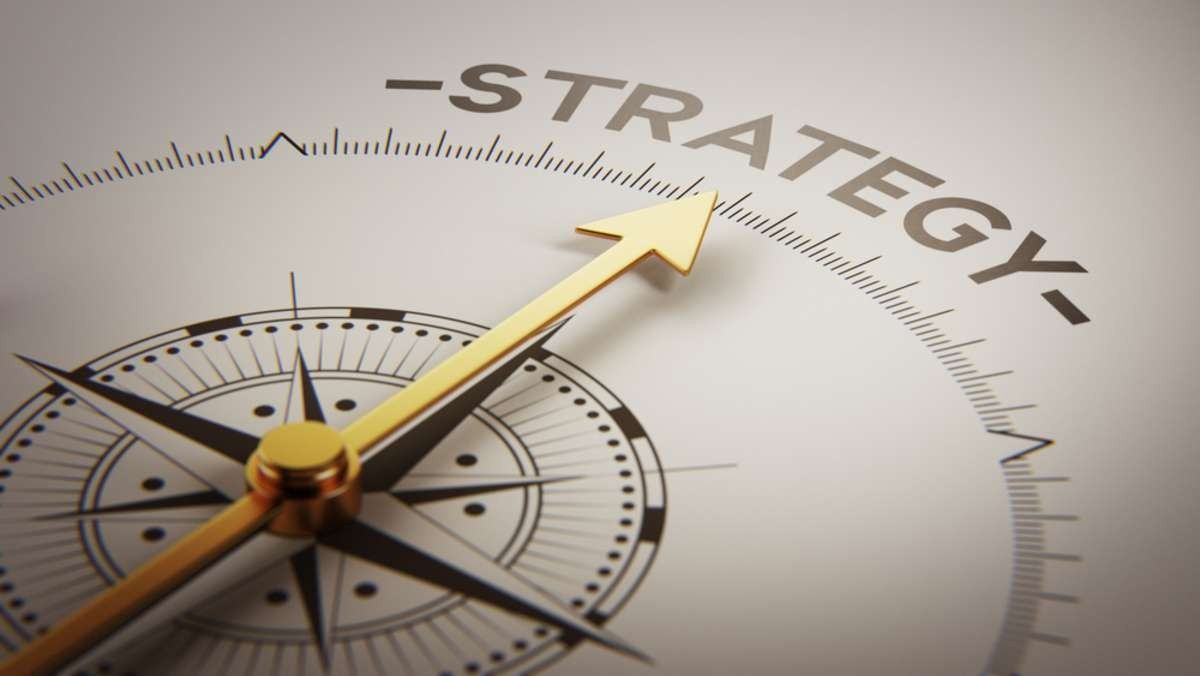 A compass with an arrow pointing to the word strategy