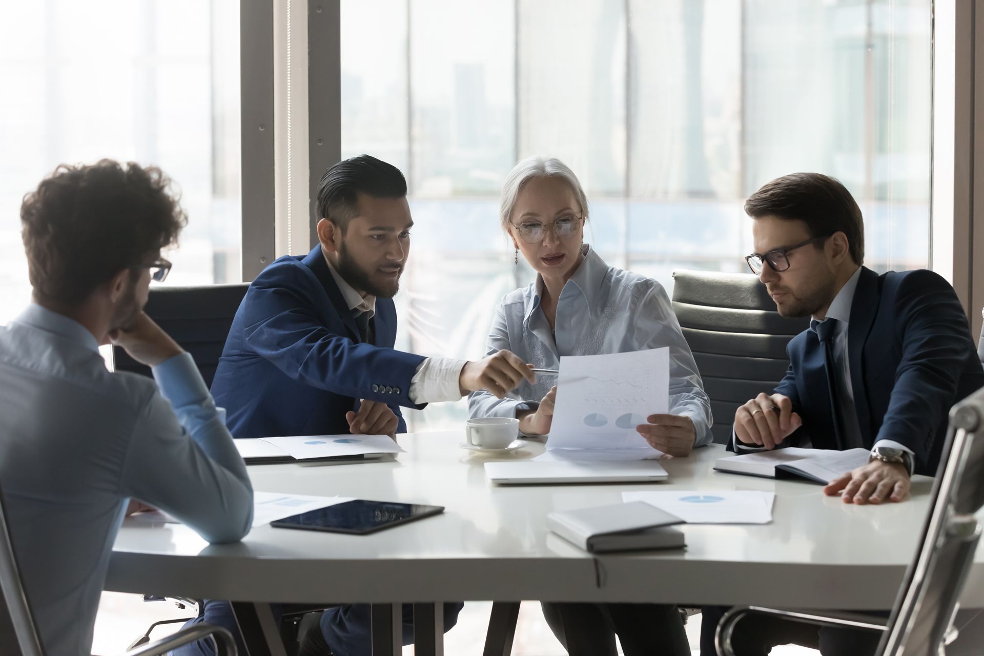 A group of business people are sitting around a table having a meeting.