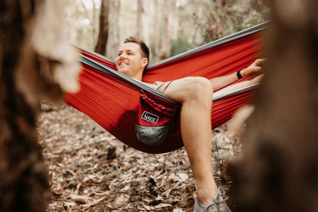 Man lying on red hammock