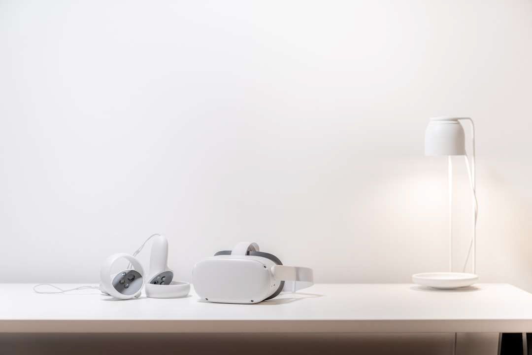 A virtual reality headset and headphones are sitting on a white table.