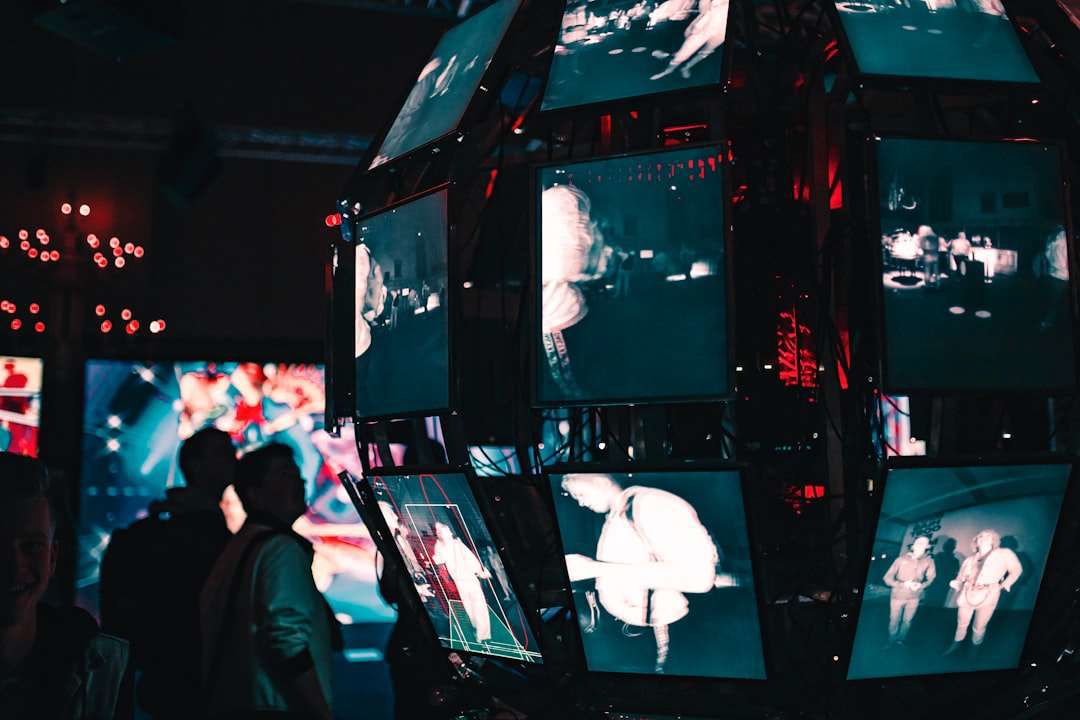 A group of people are playing a video game in a dark room.