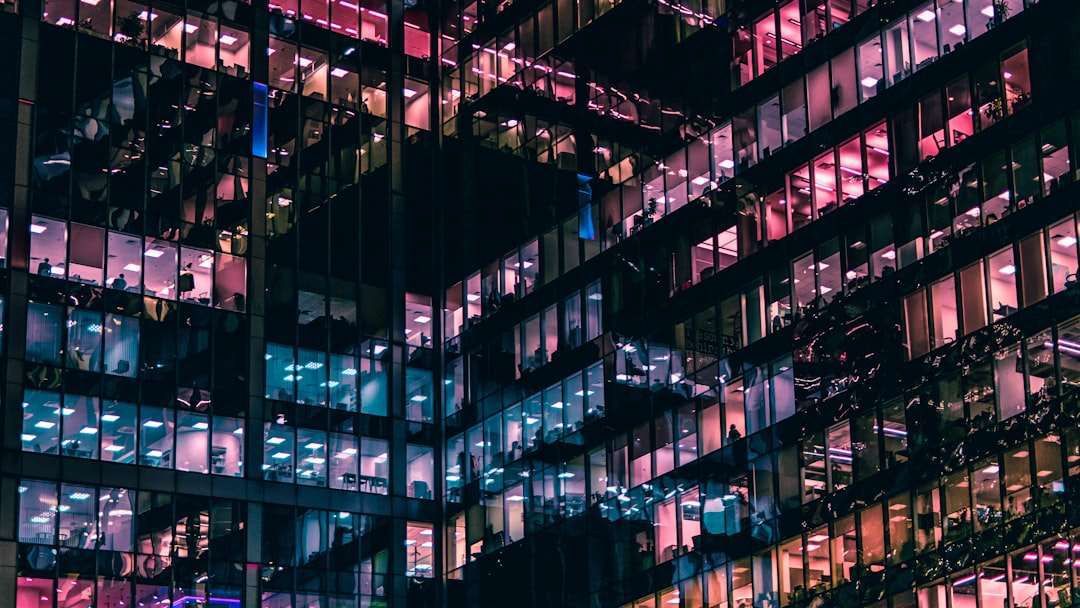 A building with a lot of windows is lit up at night.