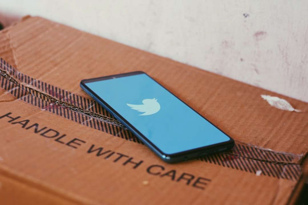 A cell phone is sitting on top of a cardboard box that says handle with care