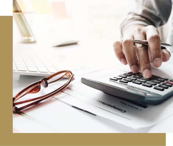 Person using a calculator with a pen, glasses and keyboard on a desk.