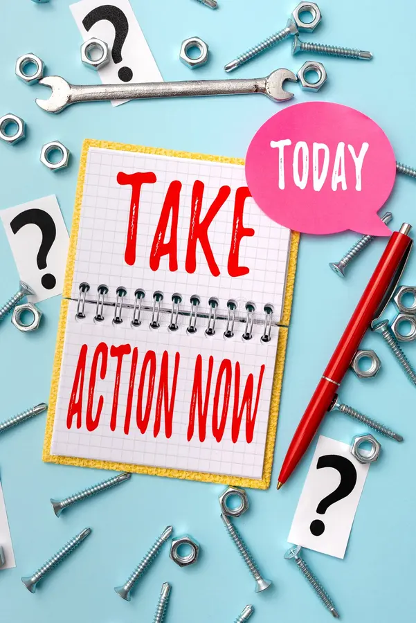 A notebook with the words `` take action now '' written on it is surrounded by nuts and bolts.