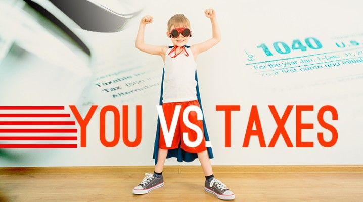 A young boy in a superhero costume is standing in front of a 1040 tax form.