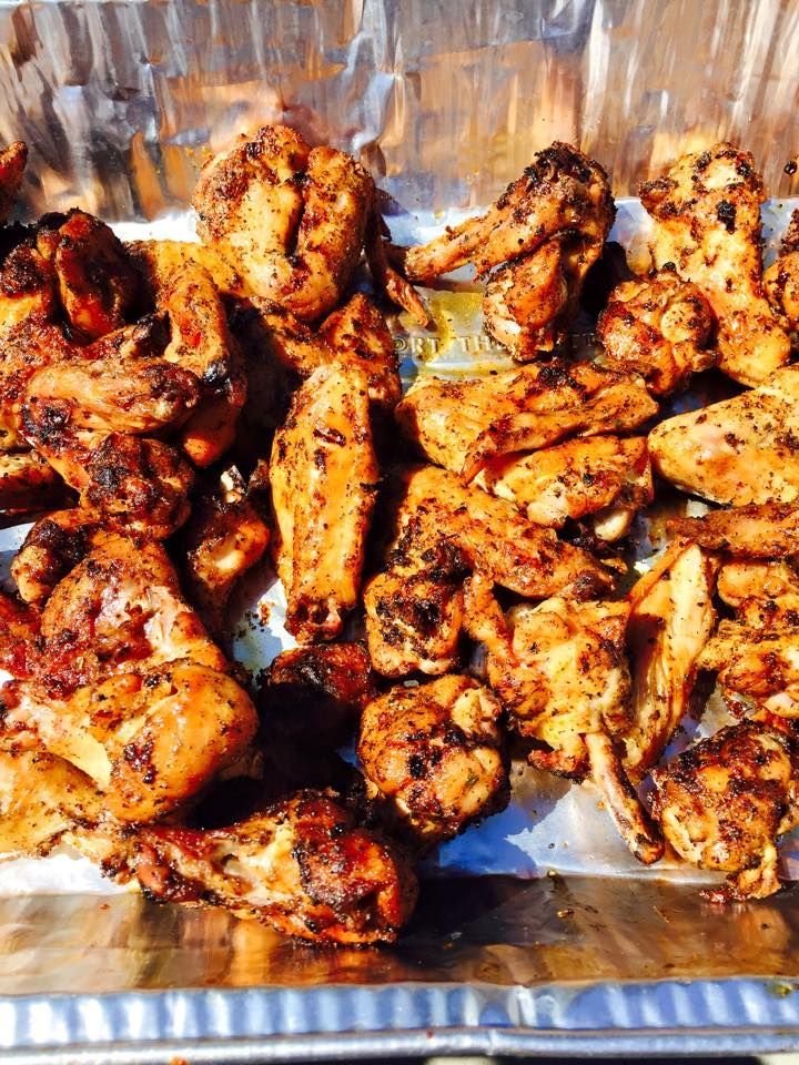 A tray of grilled chicken wings is sitting on a table.