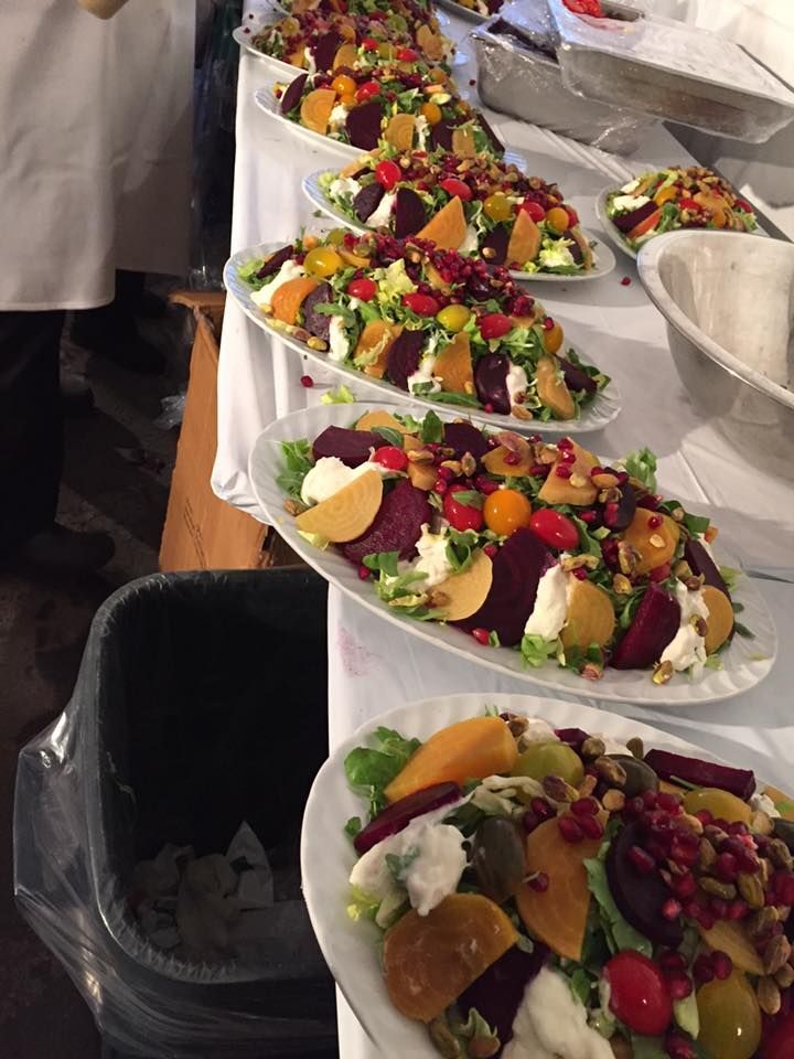 A row of salads are lined up on a table