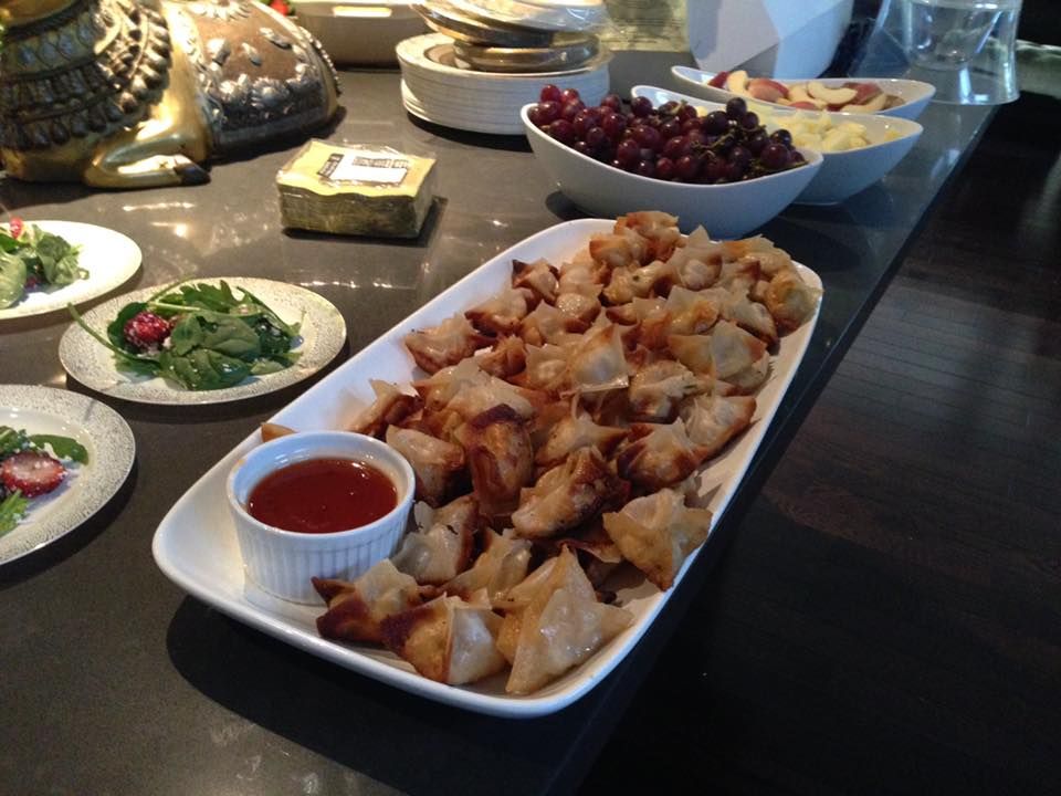 A plate of food with a small bowl of sauce on it