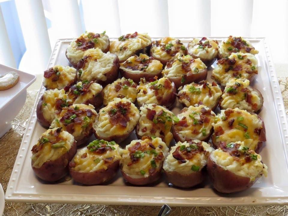 A white plate topped with potatoes stuffed with cheese and bacon.
