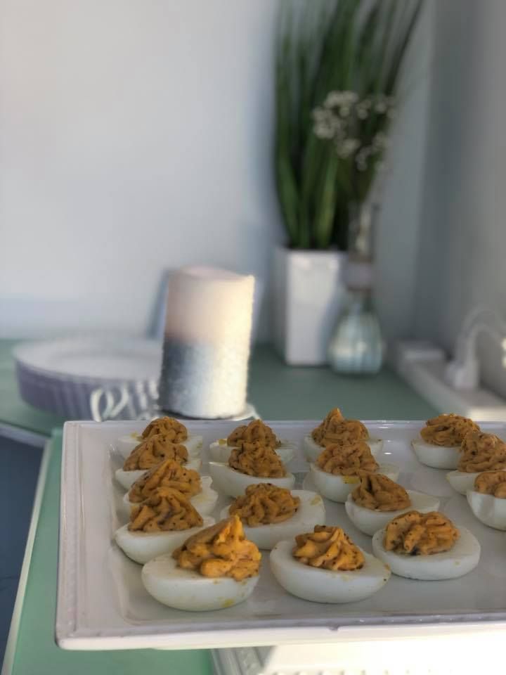 A white plate topped with stuffed eggs on a table.
