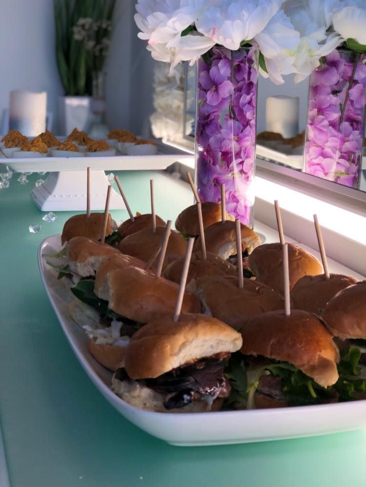 A tray of sandwiches with toothpicks in them on a table