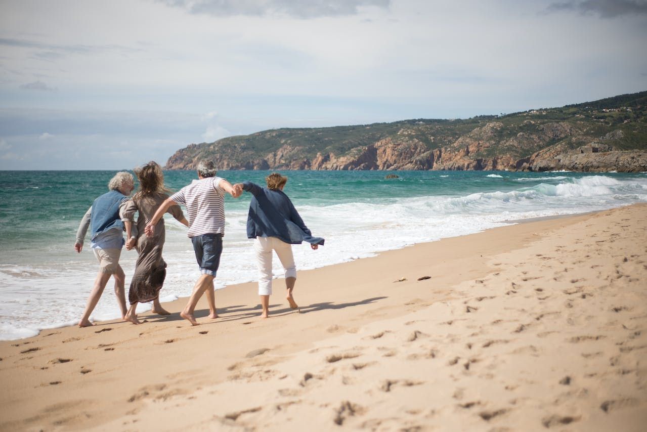 a group of people are walking on a beach .