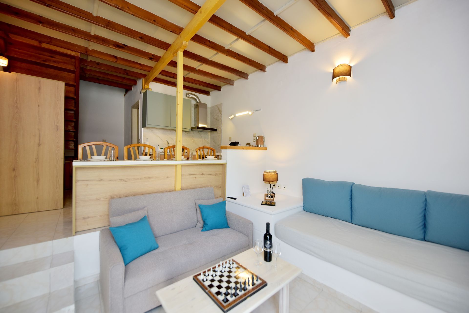 A living room with a couch and a table with a chess board on it.