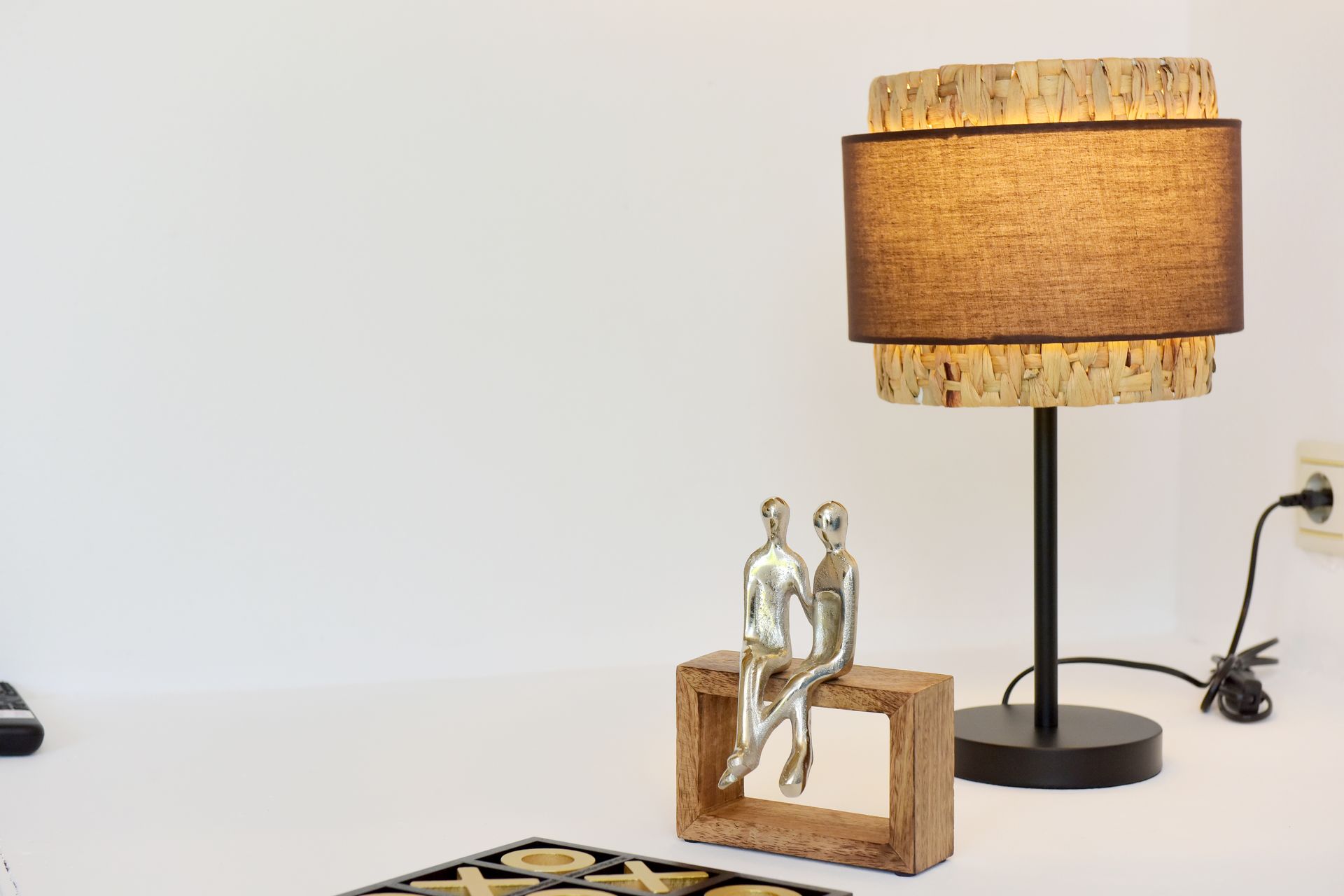 A couple of statues sitting on a wooden box next to a lamp.