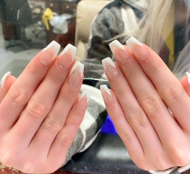 Hands with French tip coffin nails, two with small rhinestone details.