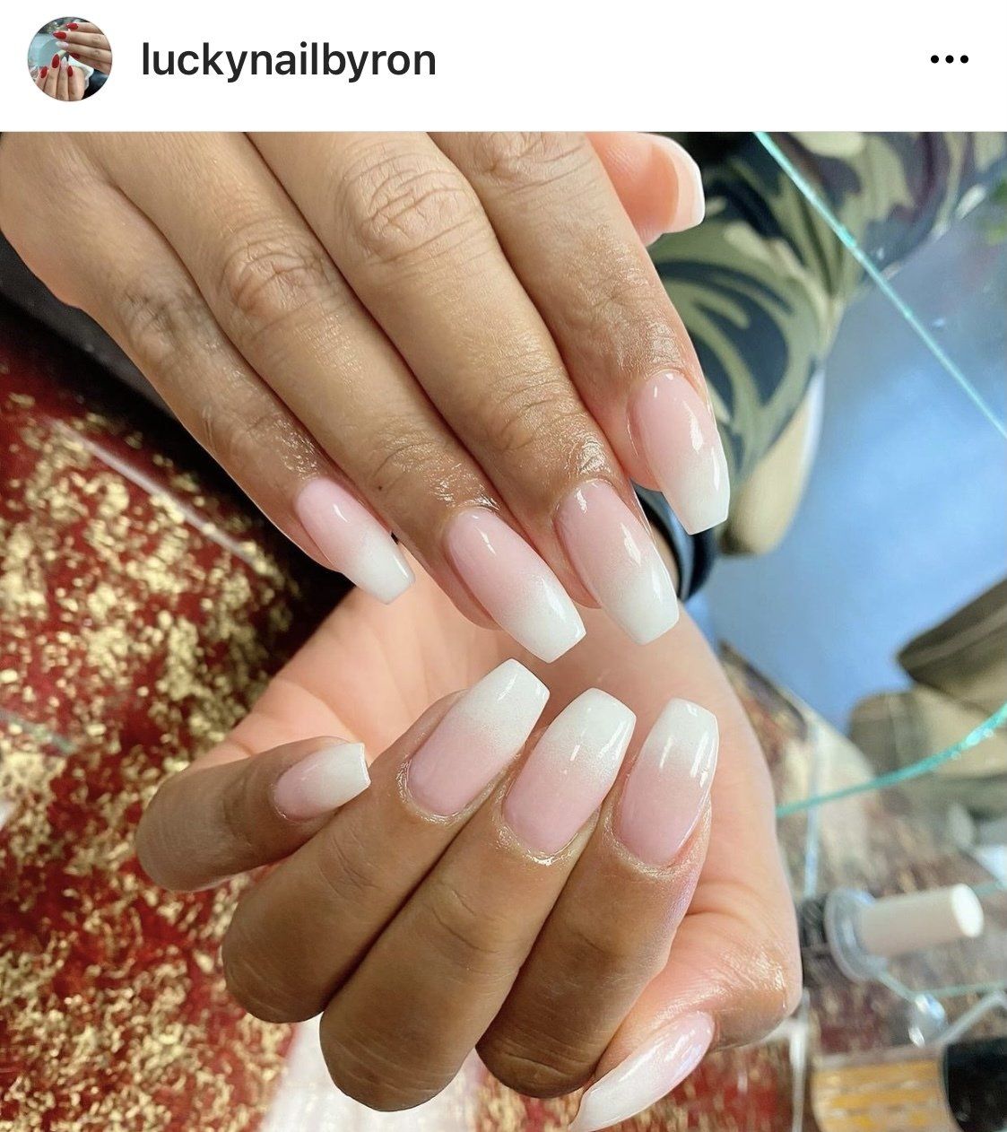 Woman's hands with coffin-shaped French tip nails, gradient from nude to white.