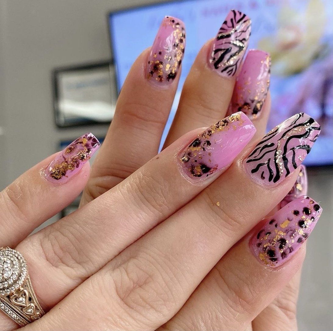 Pink and gold nail art on a hand, ring on finger, with a screen in the background.