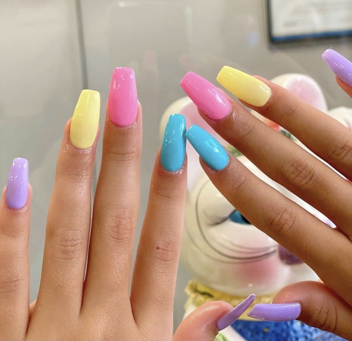 Hands with long, colorful nails: purple, yellow, pink, and blue.