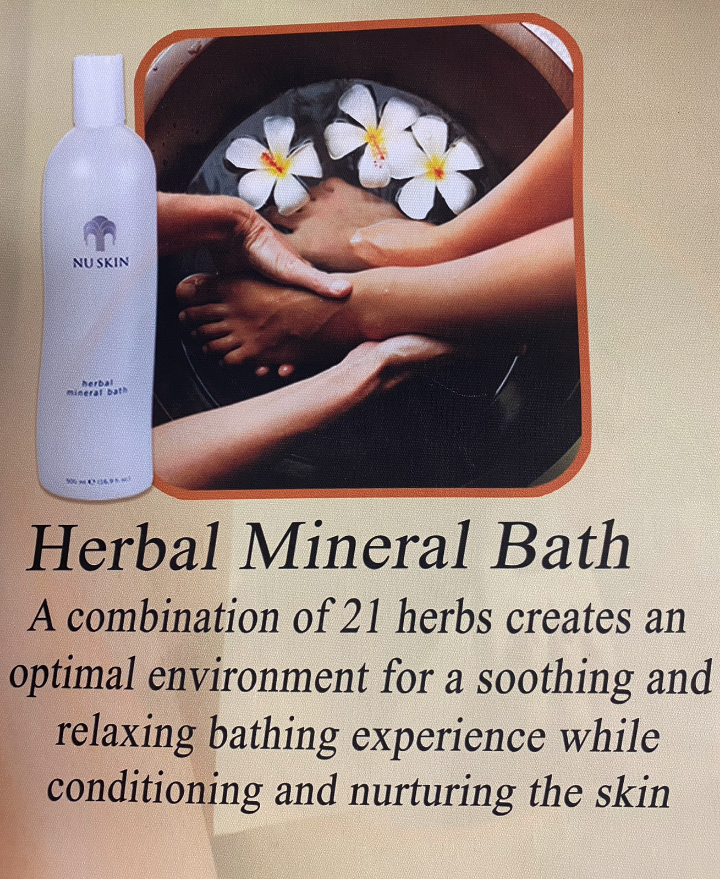 Herbal Mineral Bath ad. Bottle of product next to hands massaging feet in a bowl of water with flowers.